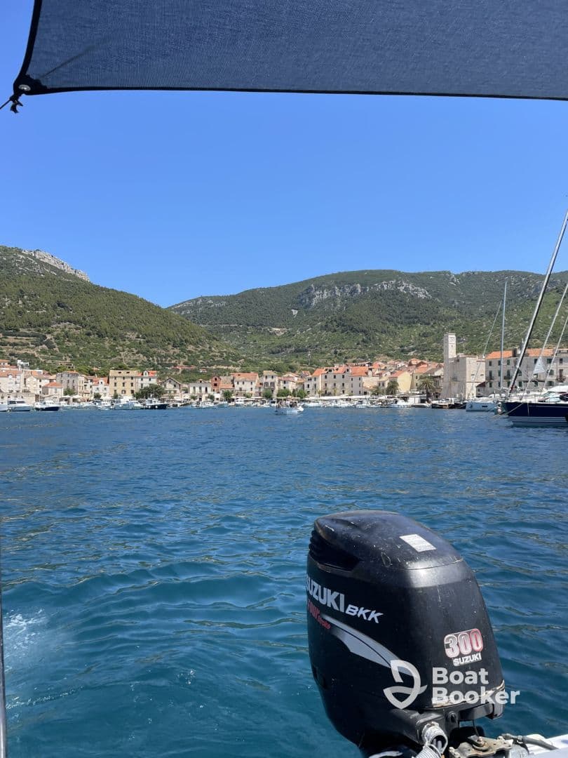 A scenic view from a boat showcasing a picturesque harbor surrounded by mountains, perfect for exploring coastal destinations.