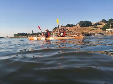 A couple enjoys kayaking on calm waters, surrounded by scenic landscapes — a perfect way to explore nature and stay active.