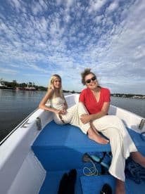 Two friends enjoy a sunny day on a boat, capturing the essence of friendship and outdoor adventure on the water.