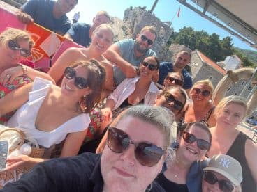 A lively group of friends gathers for a fun selfie aboard a boat, capturing the joy of their day on the water — perfect for celebrations and memorable outings.