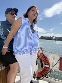A couple enjoys their time on a boat, capturing a moment of relaxation and connection against a scenic waterfront backdrop.