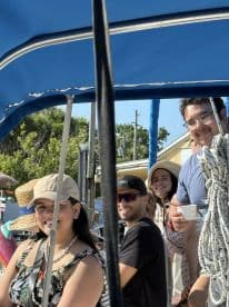 A cheerful group of friends enjoys their time aboard a boat, capturing the essence of fun and camaraderie on the water.