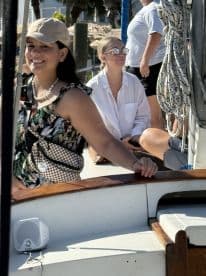 A cheerful group of friends enjoys their time aboard a boat, showcasing smiles and camaraderie in a vibrant setting.