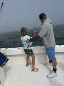 A child and an adult enjoy a fishing trip together on a boat, creating cherished memories on the open water. Perfect for family bonding and outdoor adventures.