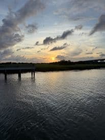 A stunning sunset reflects on the water, creating a picturesque scene perfect for evening boat trips or relaxation by the shore.