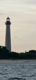 A picturesque view of a lighthouse along the coastline, capturing the serene beauty of the landscape — perfect for coastal adventures and sightseeing.