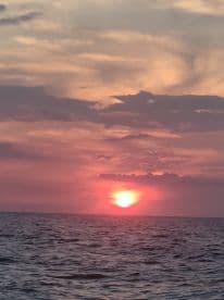 A stunning sunset over the ocean, creating a picturesque backdrop for evening boat cruises and serene moments on the water.