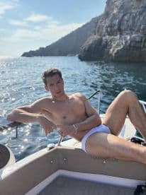 A man relaxes on the deck of a boat, enjoying the sun and scenic views — perfect for summer outings and leisurely days on the water.