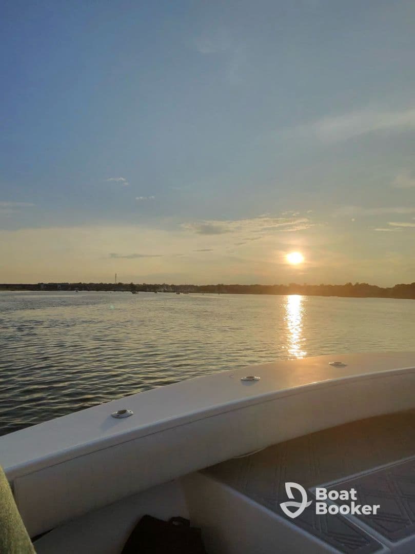 A serene sunset view from the deck of a boat, showcasing tranquil waters and a picturesque horizon — perfect for evening cruises.