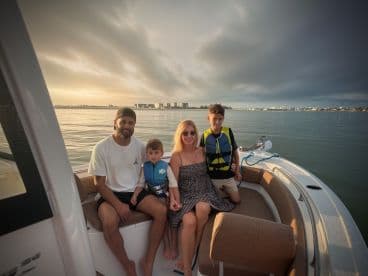 A family enjoys a picturesque sunset on a boat, creating lasting memories together on the water — perfect for family outings and adventures.
