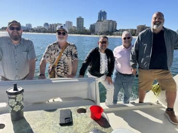 A group of friends enjoys a day out on the water, showcasing camaraderie and the beautiful coastline in the background — perfect for memorable boating adventures.