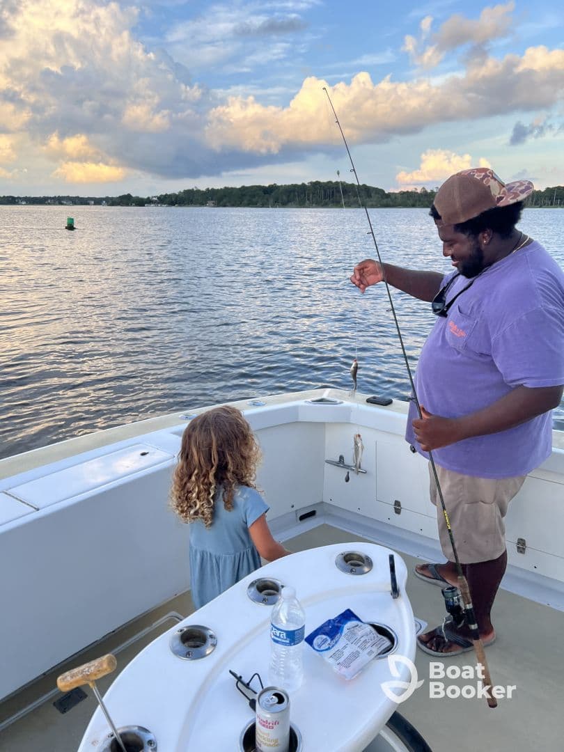A joyful moment on the water as a man shows a child their catch while fishing from a boat — a perfect family bonding experience on the water.