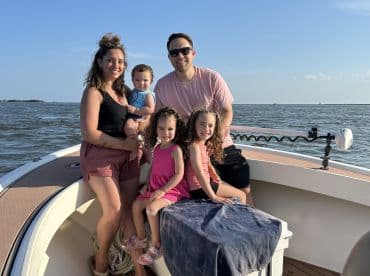 A joyful family poses together on a boat, capturing a perfect moment of fun and togetherness on the water.