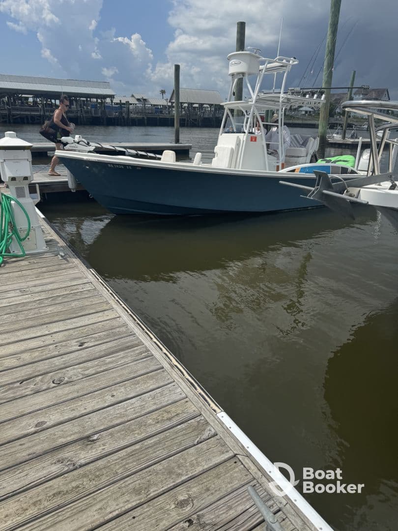 A man prepares to board a fishing boat at the dock, showcasing the excitement of a day on the water.