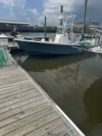 A man prepares to board a fishing boat at the dock, showcasing the excitement of a day on the water.