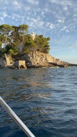 A picturesque view of a lighthouse perched on a rocky island, surrounded by tranquil waters and a beautiful sky — a perfect representation of coastal scenery.