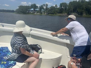 Two guests enjoy a sunny day on the boat, engaging in conversation while taking in the scenic views — perfect for a relaxing outing on the water.