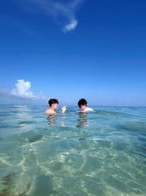 Two friends enjoy a refreshing swim in crystal-clear waters, capturing the essence of a perfect day on the water.