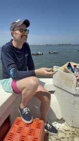 A man enjoys a sunny day on a boat, showcasing a relaxed atmosphere perfect for fishing or leisure activities on the water.