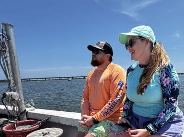 A joyful moment on the water as a couple enjoys their boat ride, showcasing the fun and relaxation of a day out on the sea.