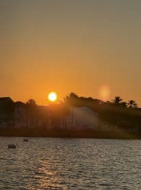 A stunning sunset casts a golden glow over the coastline, creating a picturesque scene perfect for evening boat trips and relaxation by the water.