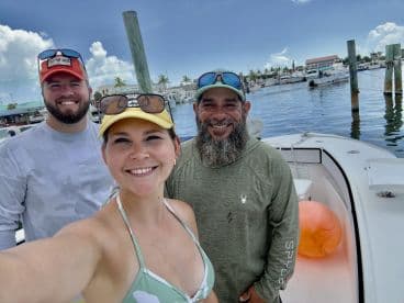 A cheerful group poses for a selfie on a boat at the marina, capturing the excitement of their upcoming adventure on the water.