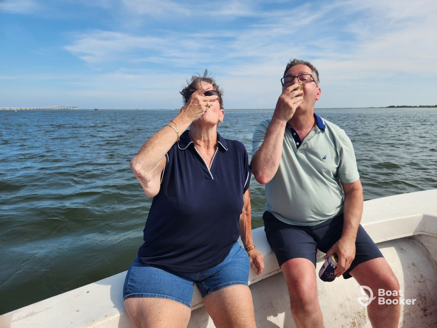 A joyful moment on the water as a couple enjoys oysters while boating, capturing the essence of a fun day out on the water.