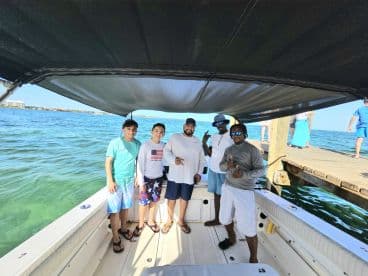 A cheerful group of friends poses on a boat, enjoying their time on the water — perfect for memorable outings and adventures.