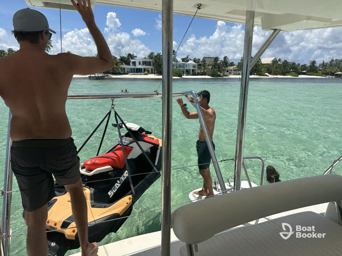 Guests enjoy a sunny day on the water, with a jet ski ready for adventure and a child swimming nearby — perfect for family fun in the clear turquoise waters.