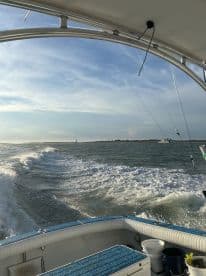 A scenic view from the helm of a boat, showcasing the vessel in motion with a backdrop of waves and distant land — perfect for capturing the essence of a day on the water.
