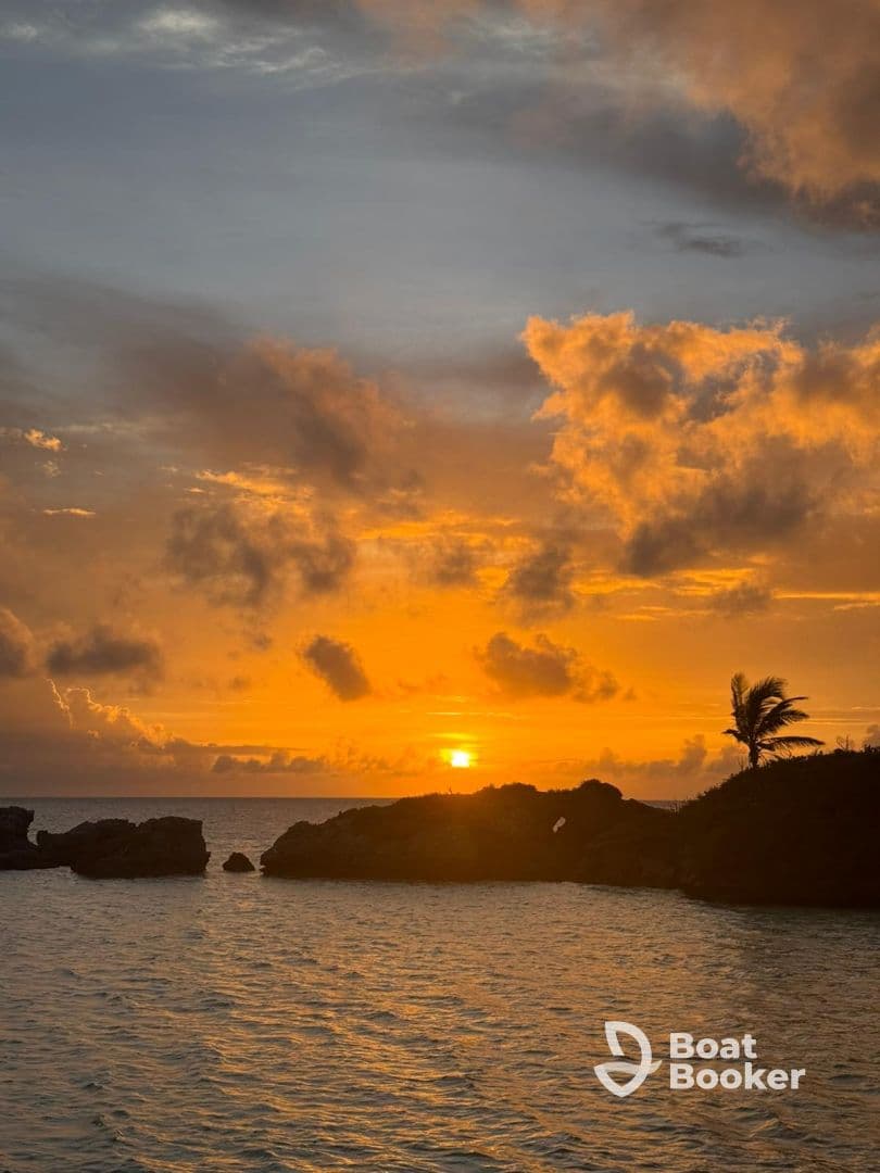 A breathtaking sunset over the coastline, with vibrant colors reflecting on the water — a perfect backdrop for evening boat trips and island adventures.