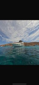 A stunning view of a yacht docked in crystal-clear waters, showcasing the beauty of the surrounding landscape and ideal for luxury boating experiences.
