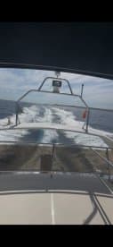 A view from the helm of a boat cruising through open waters, showcasing the vessel's wake and the expansive sky — perfect for showcasing boating adventures.