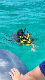 A joyful child snorkels in vibrant turquoise waters, showcasing the excitement of underwater exploration — a perfect family adventure.