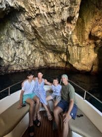 A family enjoys a moment aboard their boat inside a stunning cave, creating unforgettable memories during their adventure.