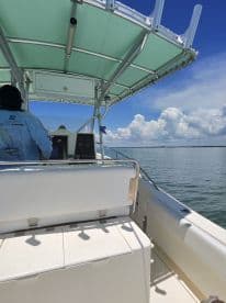 A view from the helm of a boat, showcasing the console and seating area, perfect for navigating the open waters.