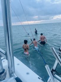 A family enjoys a fun day in the ocean, swimming and fishing together, creating unforgettable memories on the water.