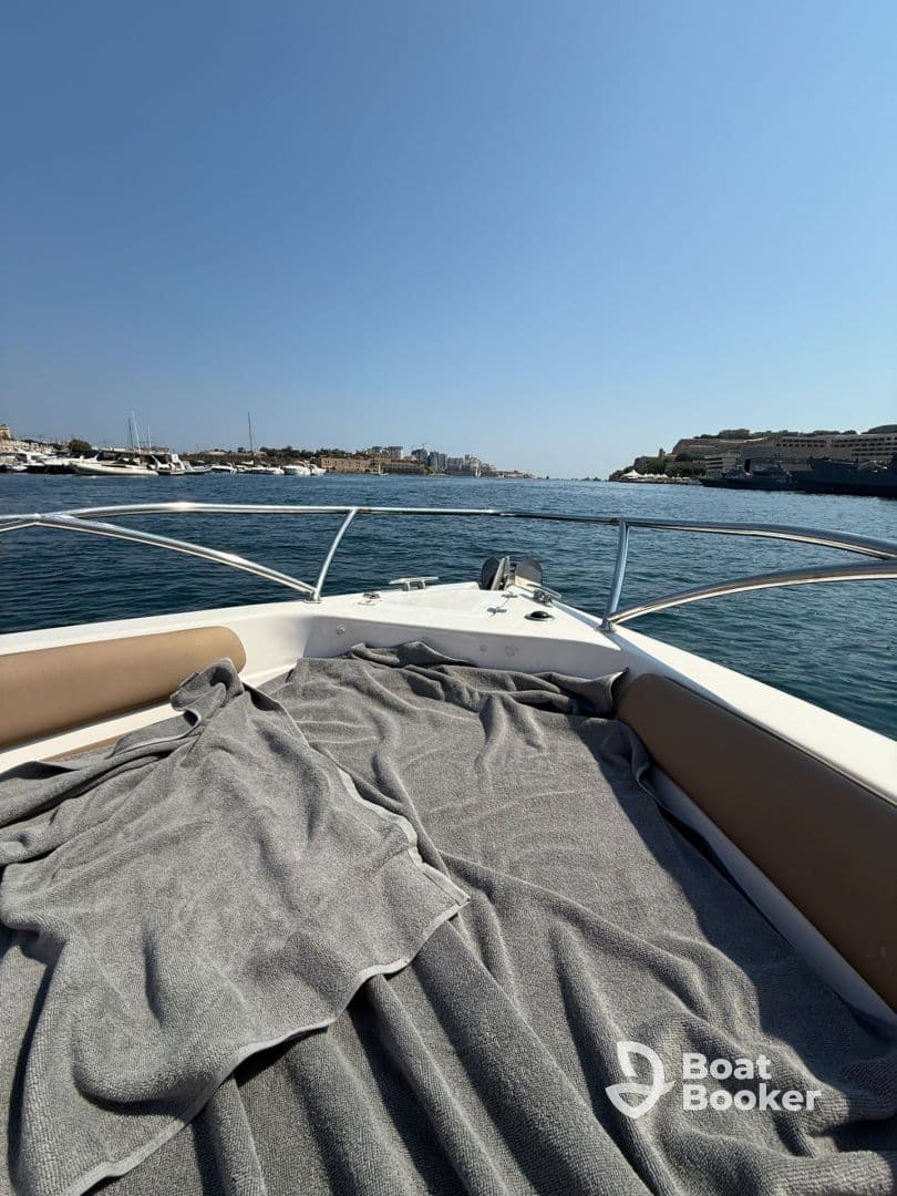 A cozy view of the interior seating area on a boat, featuring soft gray blankets, perfect for relaxing while cruising on the water.