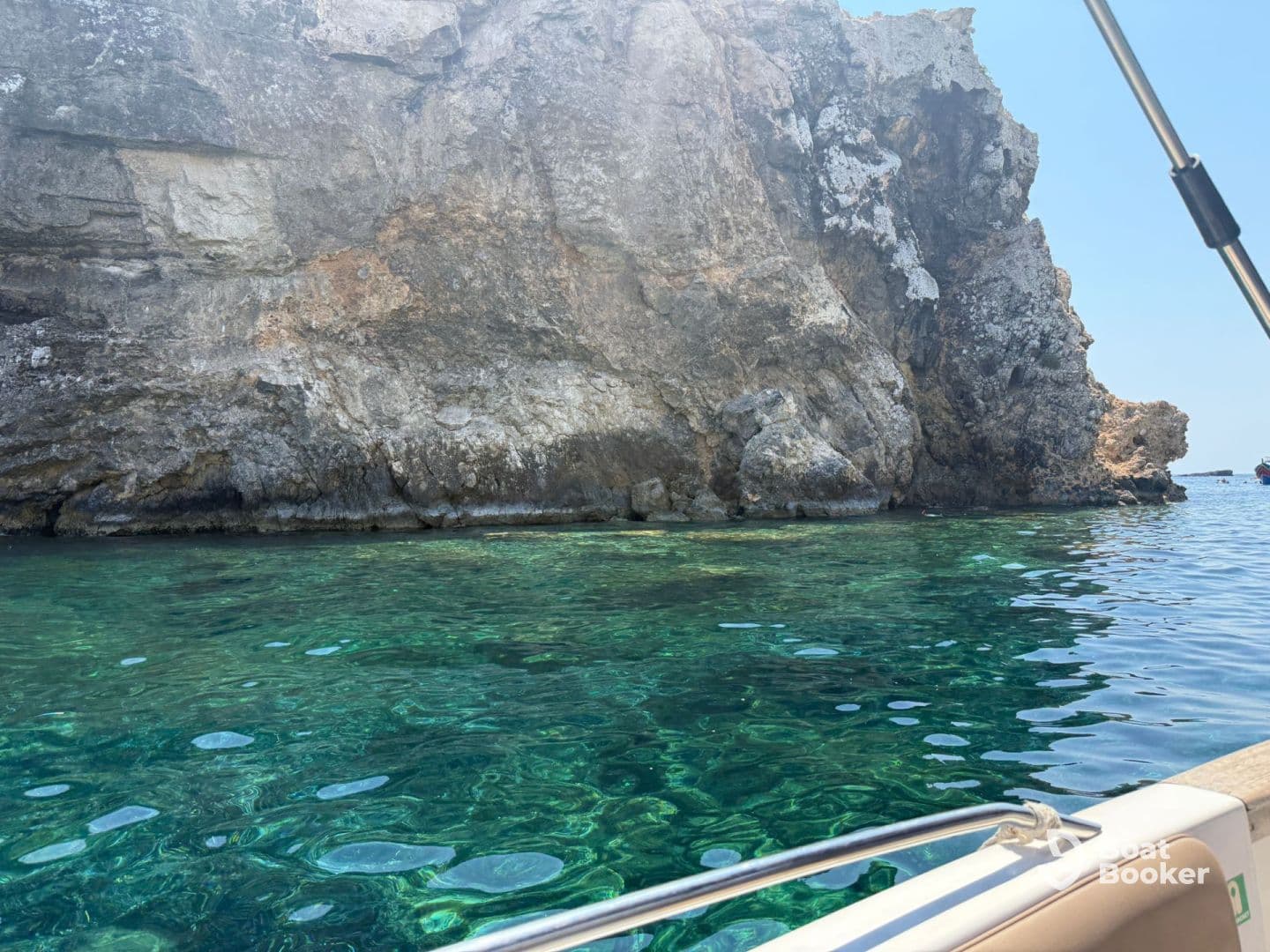 A stunning view of a rocky coastline with crystal-clear waters, perfect for exploring and enjoying the beauty of nature while boating.