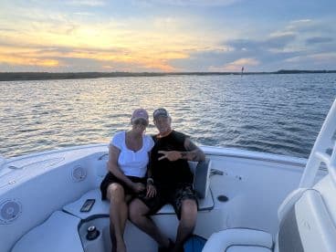 A couple enjoys a beautiful sunset on a boat, capturing a perfect moment of relaxation and celebration on the water.
