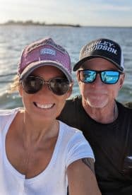 A cheerful couple enjoys a sunny day on the water, capturing a joyful selfie while boating — perfect for memorable adventures and romantic outings.