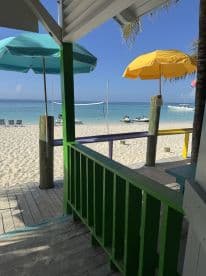 A vibrant view from a beachside structure featuring colorful umbrellas and a serene ocean backdrop, perfect for relaxation and beach activities.