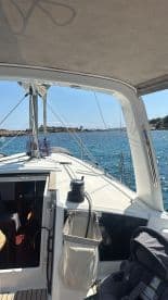 A view of the interior helm area of a sailboat, showcasing the seating and cabin space, perfect for relaxing while enjoying a day on the water.