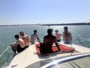 A group of friends enjoys a sunny day on the boat, relaxing and taking in the beautiful water views — perfect for a fun day out on the water.