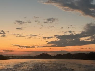 A serene sunset view over the water, showcasing the tranquil beauty of the evening sky — perfect for romantic boat rides or peaceful escapes.
