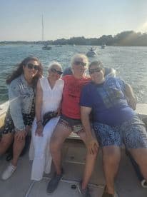 A joyful group of family members enjoying a sunny day on a boat, capturing the essence of summer fun and togetherness on the water.