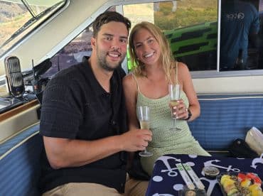 A couple enjoys a celebratory toast with cocktails inside a boat, creating a perfect atmosphere for special moments on the water.