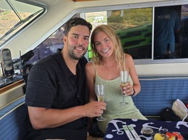 A couple enjoys celebratory cocktails inside a boat, creating a perfect atmosphere for special moments on the water.