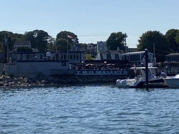 A scenic view of TKO Malley's restaurant from the water, showcasing boats docked at the waterfront — a perfect spot for dining and enjoying the marine atmosphere.