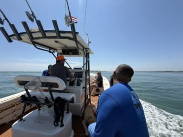 A group of friends enjoys a day on the water aboard a fishing boat, capturing the essence of camaraderie and adventure in the sun.